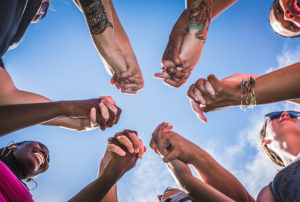 people holding hands together under sky