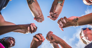 people holding hands together under sky