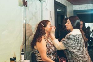 volunteer applying eyeliner on a model